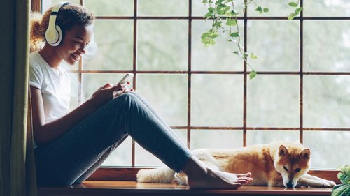 Woman listens to music with her dog.